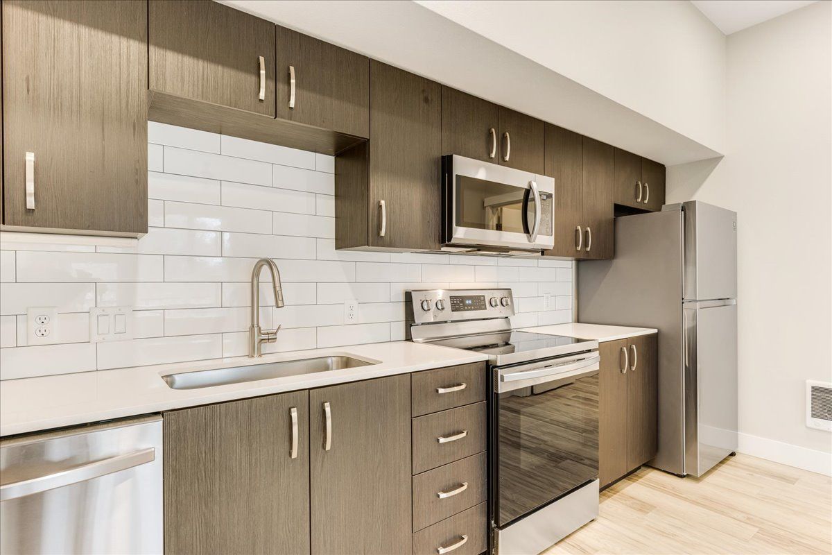 a kitchen with stainless steel appliances and wooden cabinets .