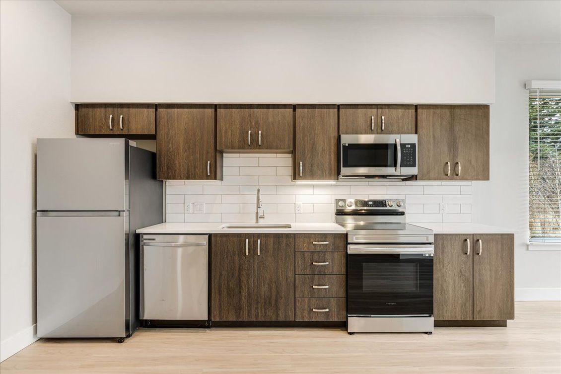 a kitchen with stainless steel appliances and wooden cabinets