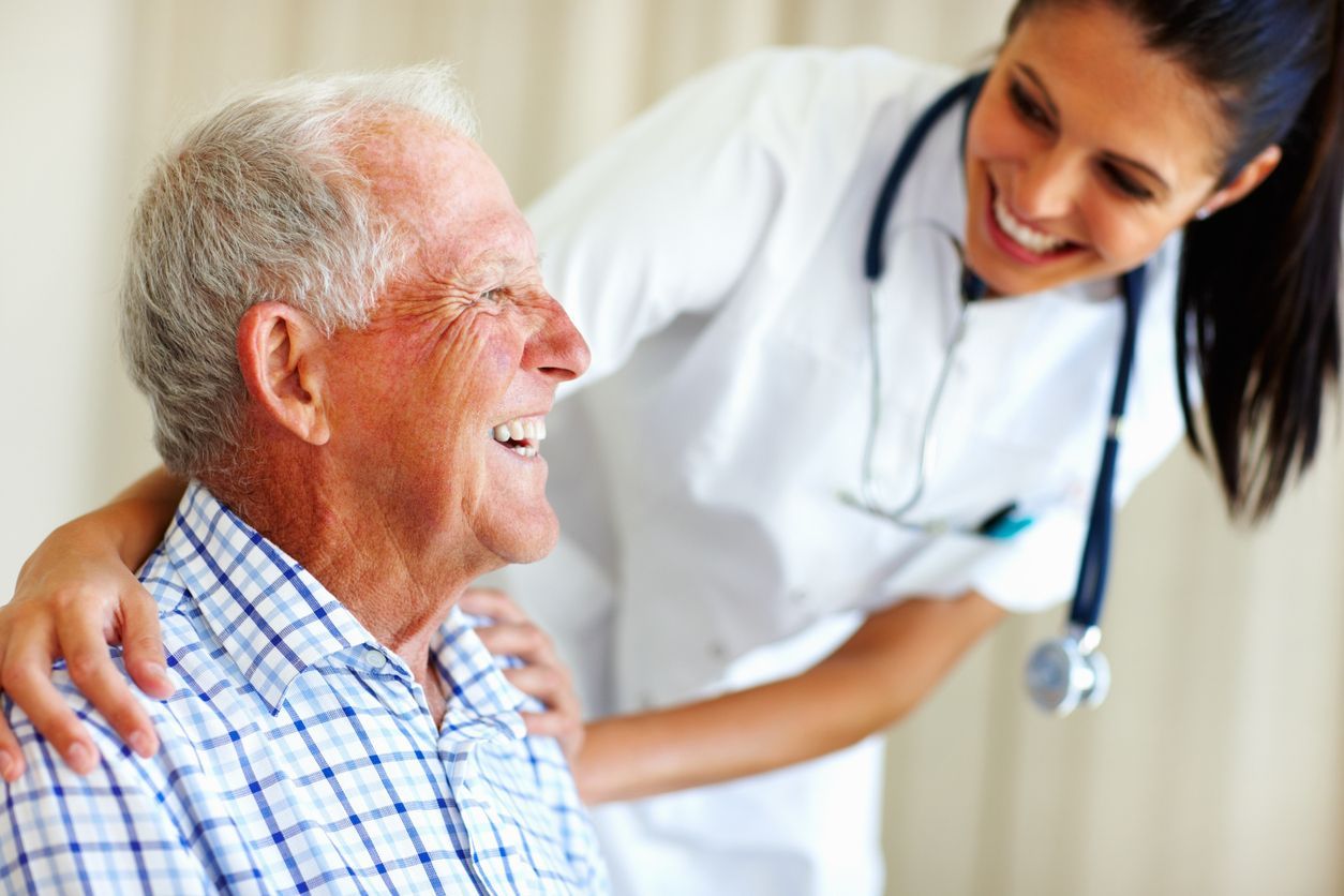 Comprehensive Health Screening: elderly male patient and doctor smiling at each other in the clinic.