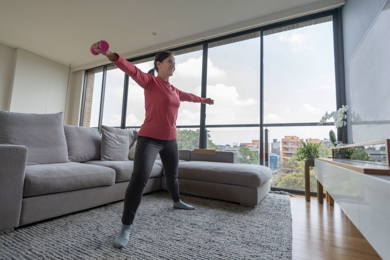 Boosting immune health - A woman exercising indoors during the cold season.
