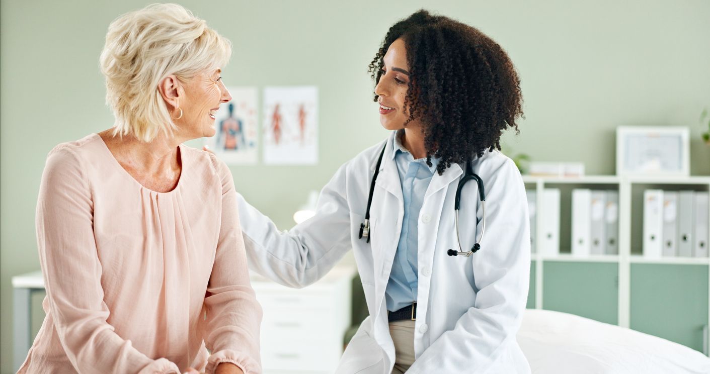 Reduce inflammation in women - A senior female patient consulting with a doctor inside a clinic.