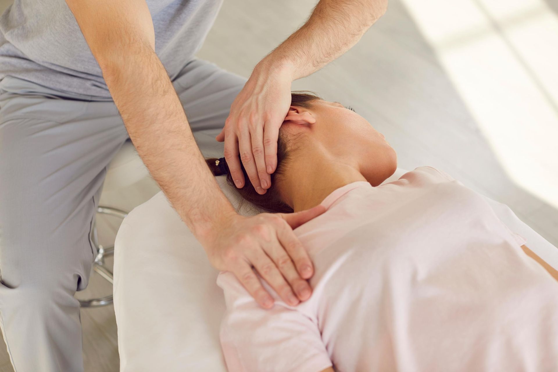 Person receiving neck massage from a practitioner.