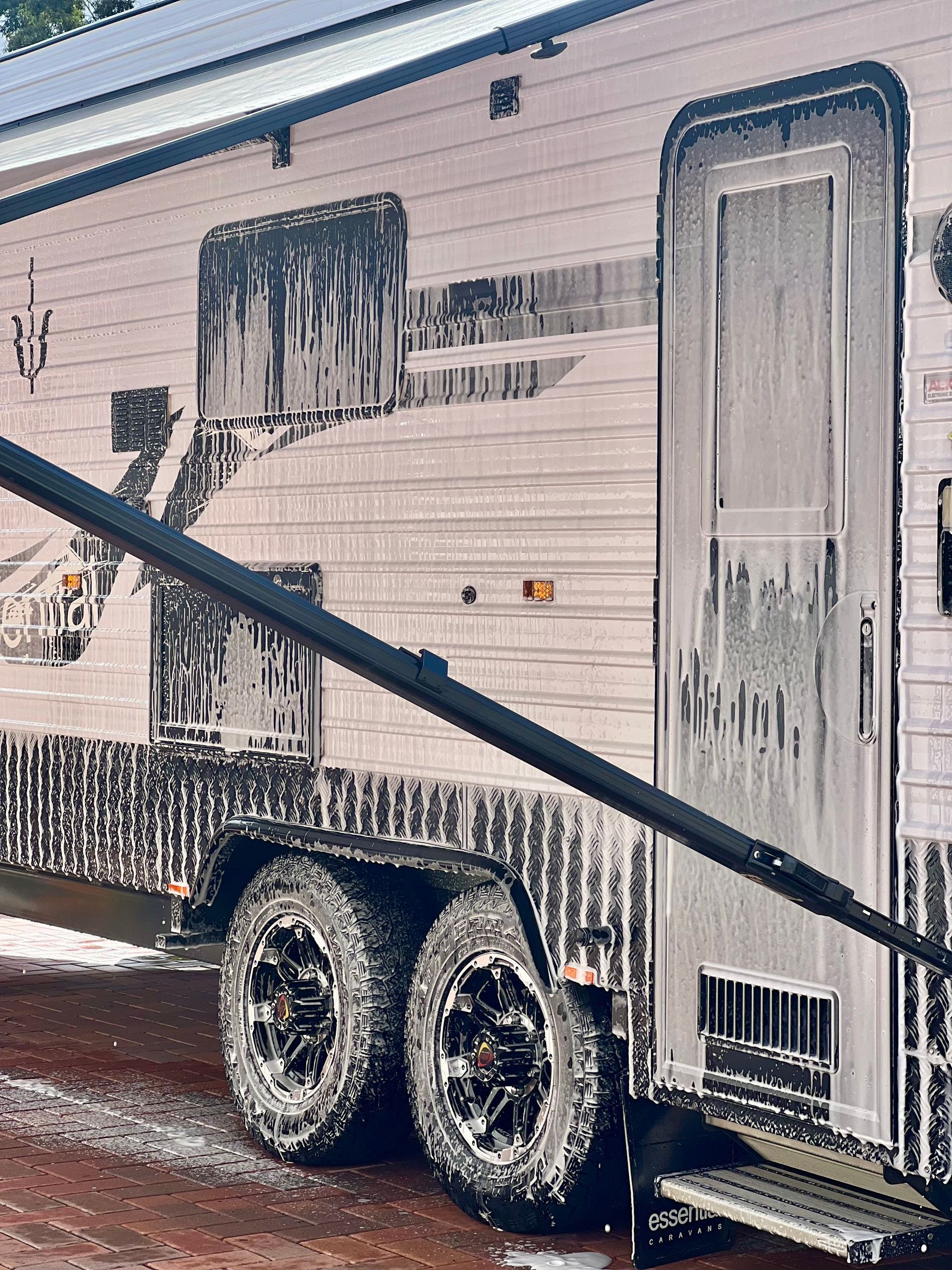 A man is cleaning a trailer with a spray bottle.