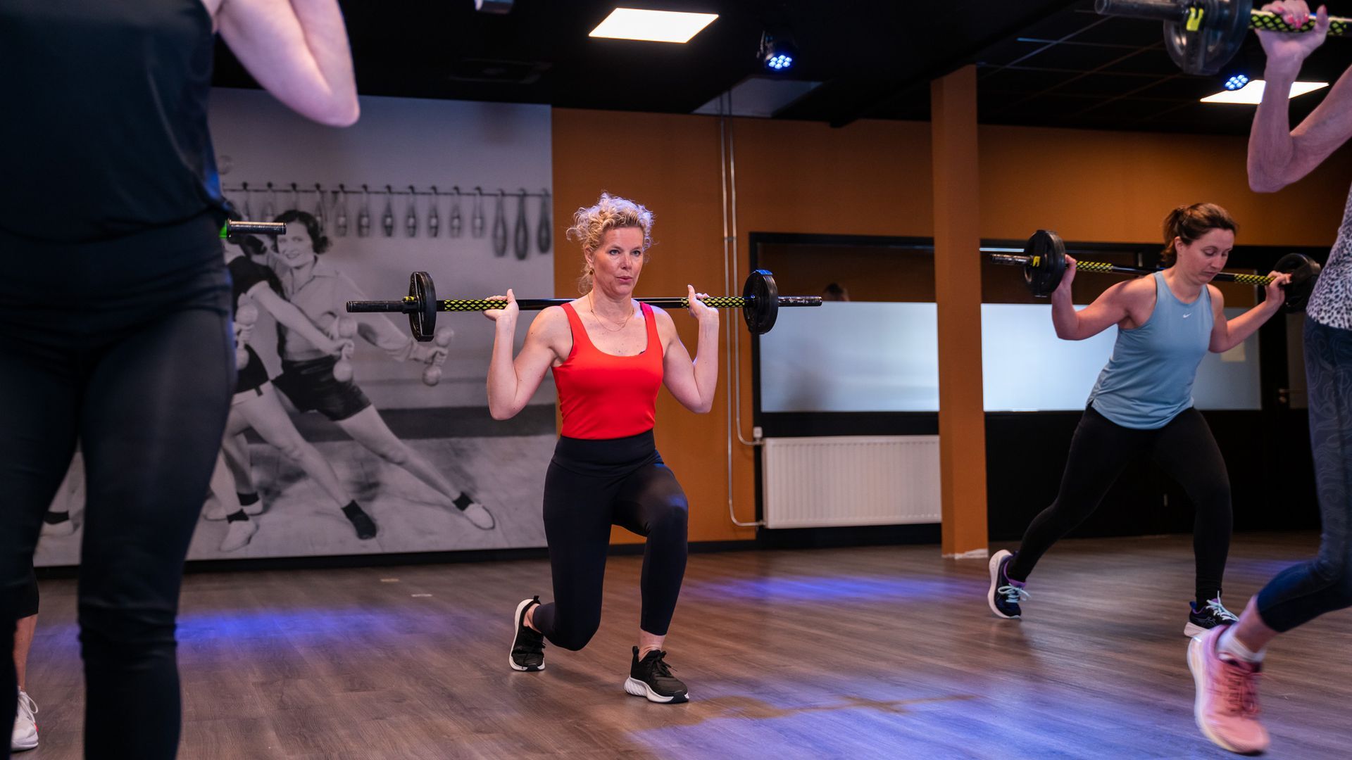 Een vrouw doet een squat in een sportschool.