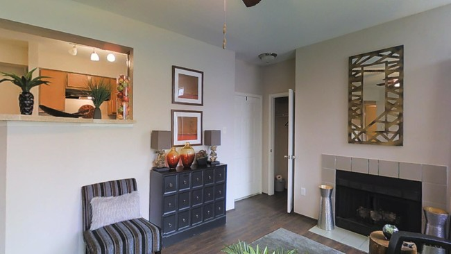 A living room with a fireplace , chairs and a dresser.
