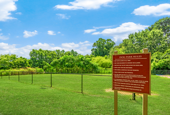 There is a sign in the middle of a grassy field.