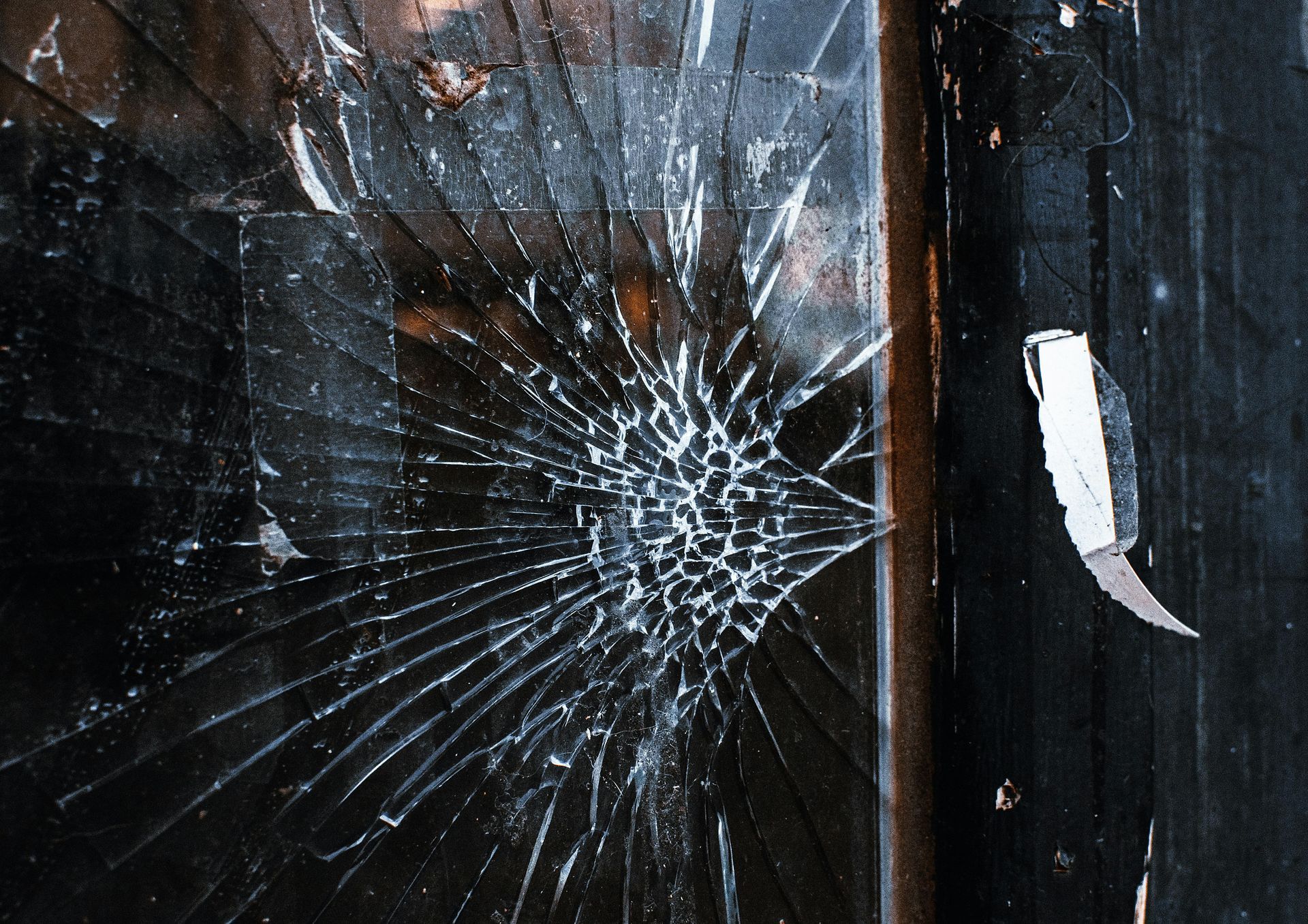 A close up of a broken glass window with the letter a on it