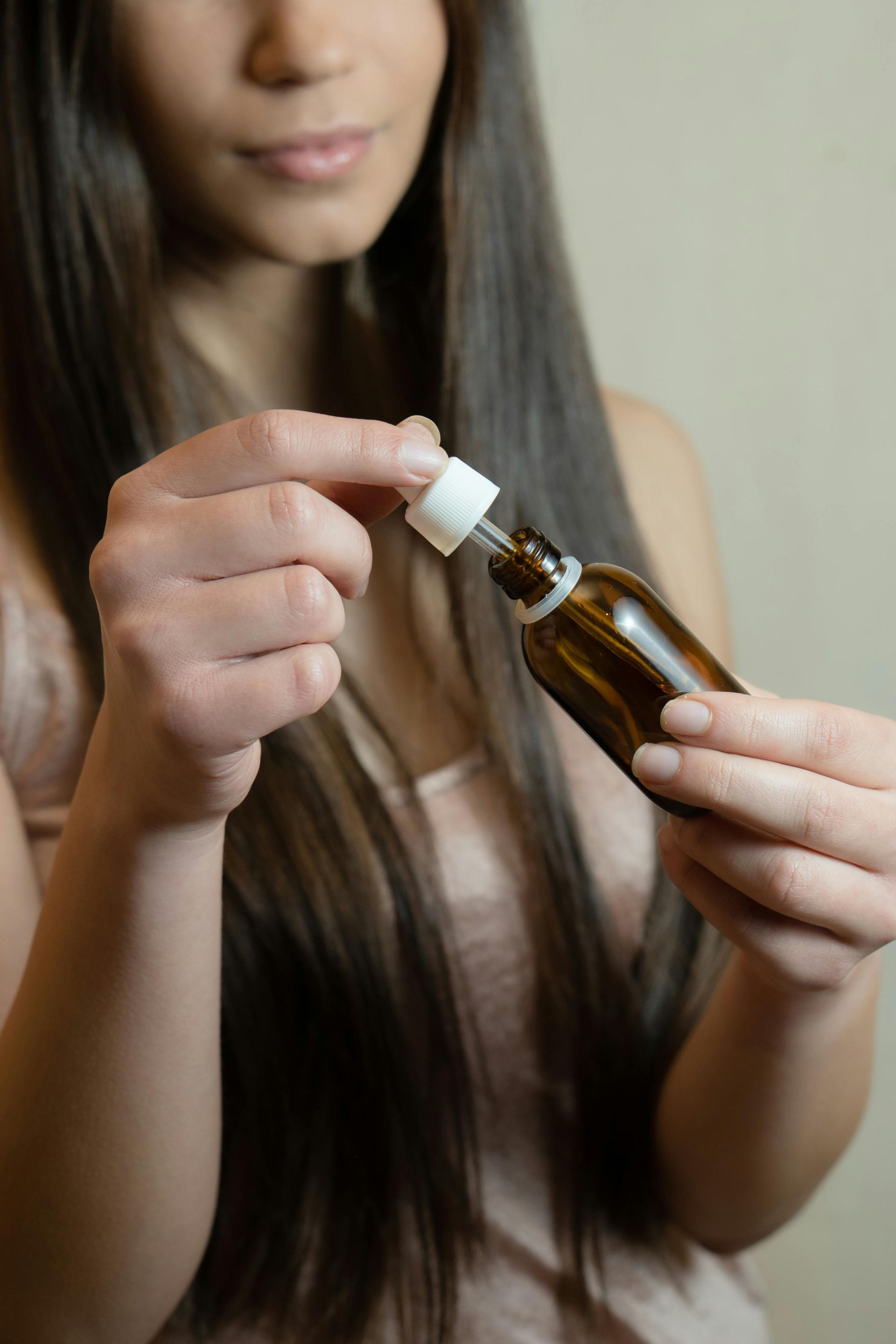 A woman is holding a bottle of liquid in her hands.