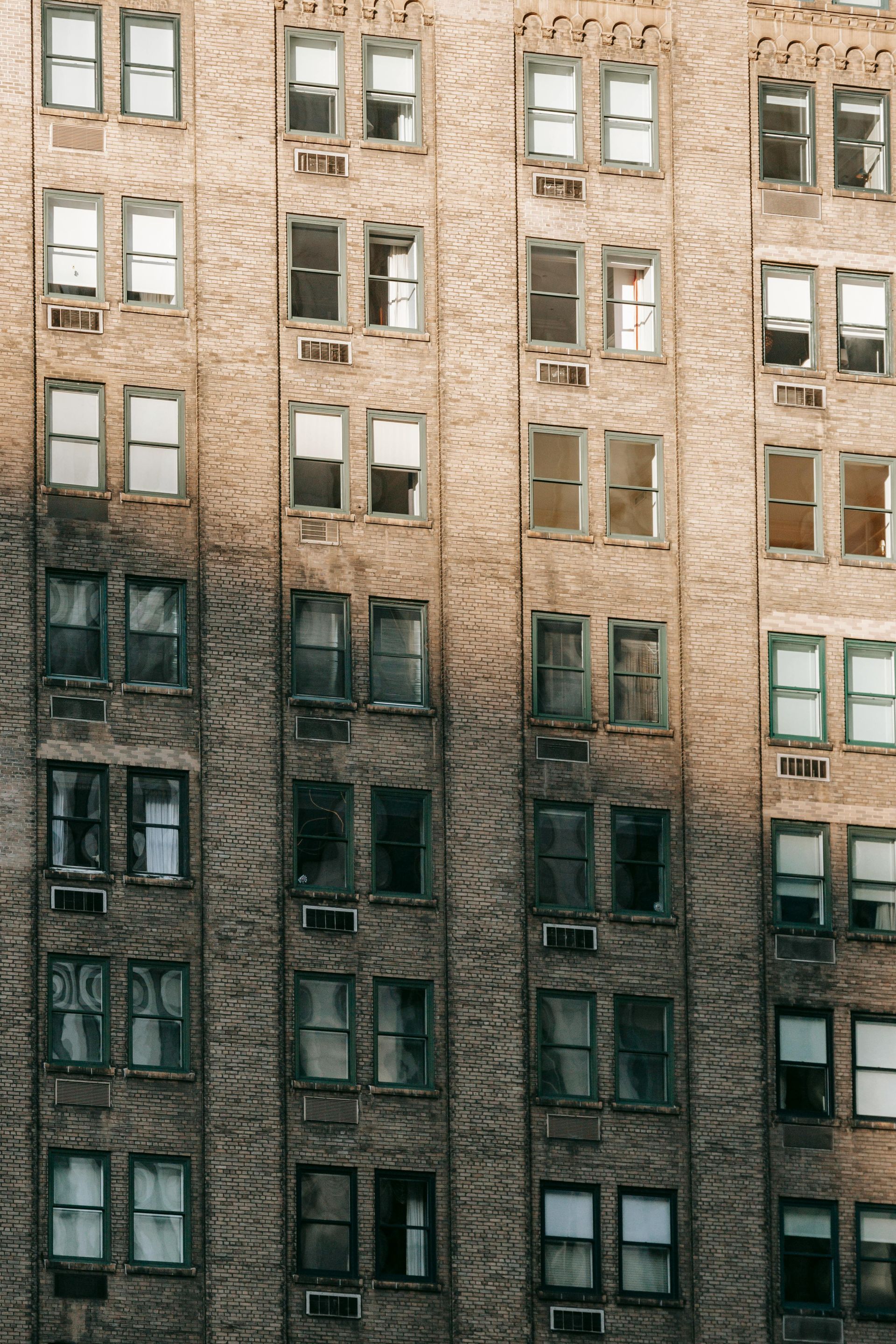 A tall building with a lot of windows and shadows on it