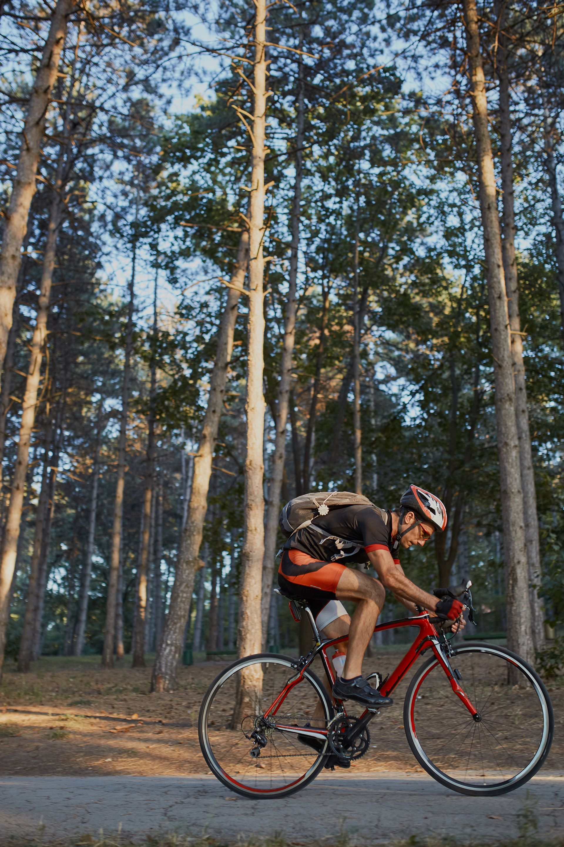 A man is riding a bike on a path in the woods.