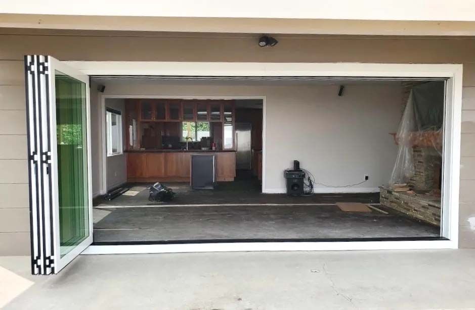 A large sliding glass door is open to a kitchen.