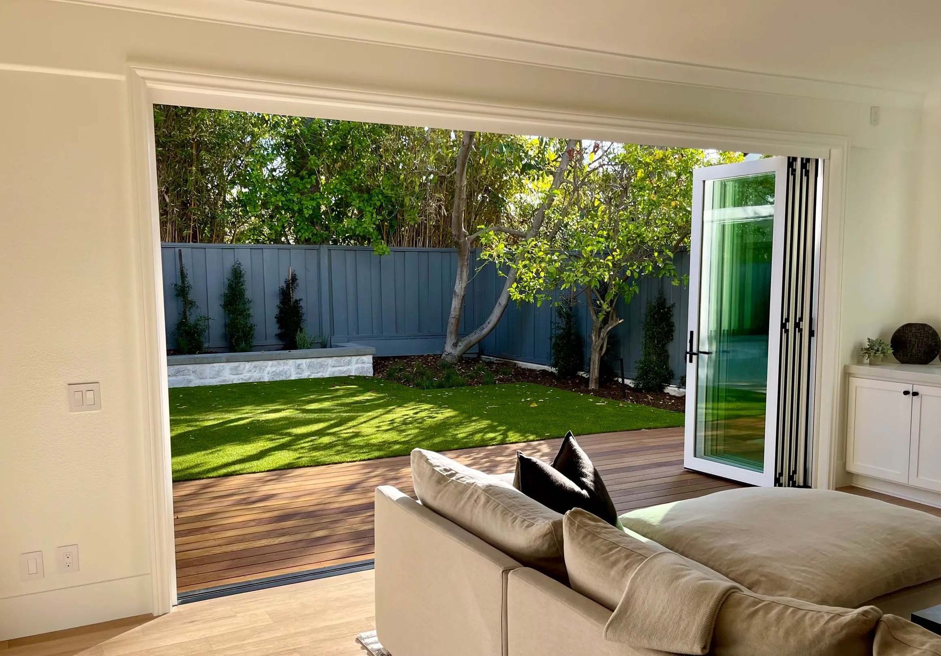 A living room with a couch and sliding glass doors leading to a backyard.