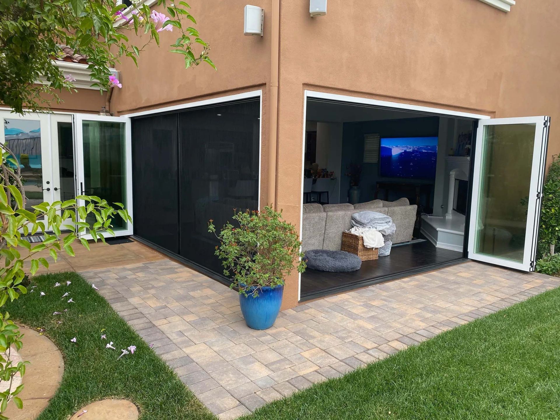 A house with a patio and sliding glass doors that open to a living room.