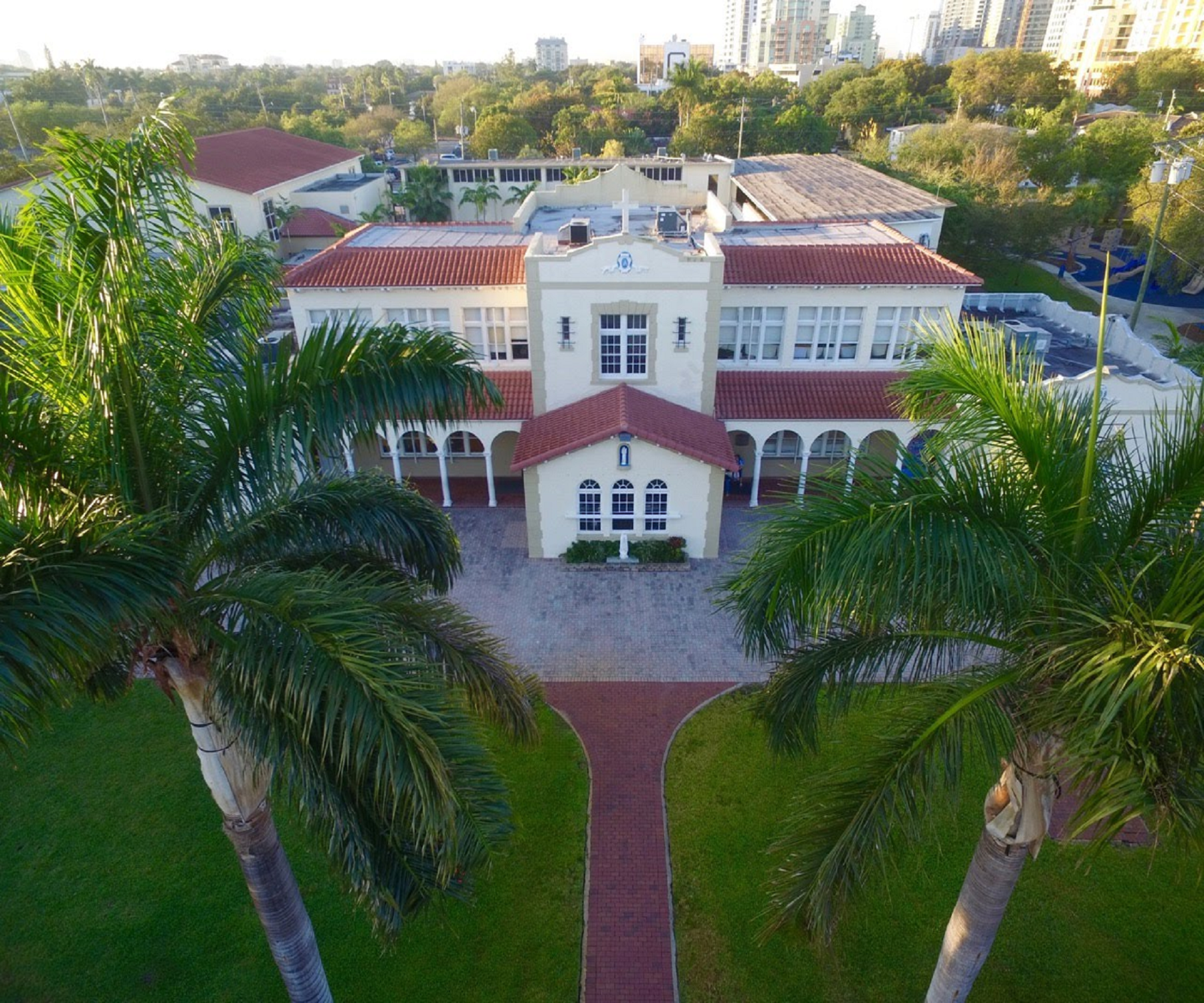 an aerial view of a large white building with a red tile roof