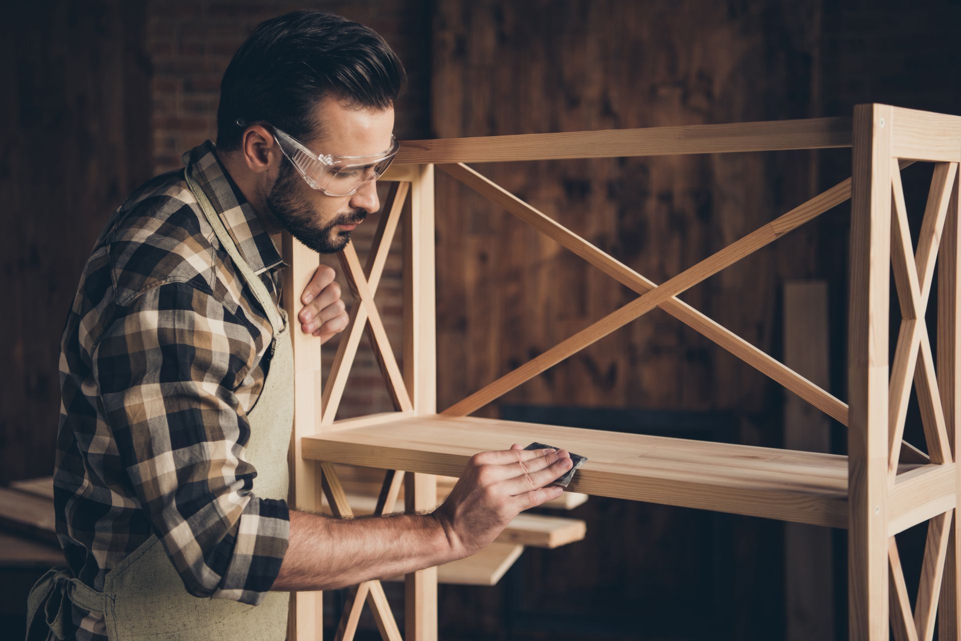 a woodworker sanding timber furniture