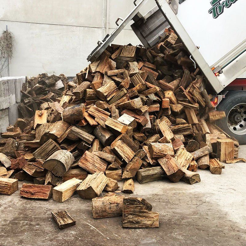 a truck unloading heaps of firewood