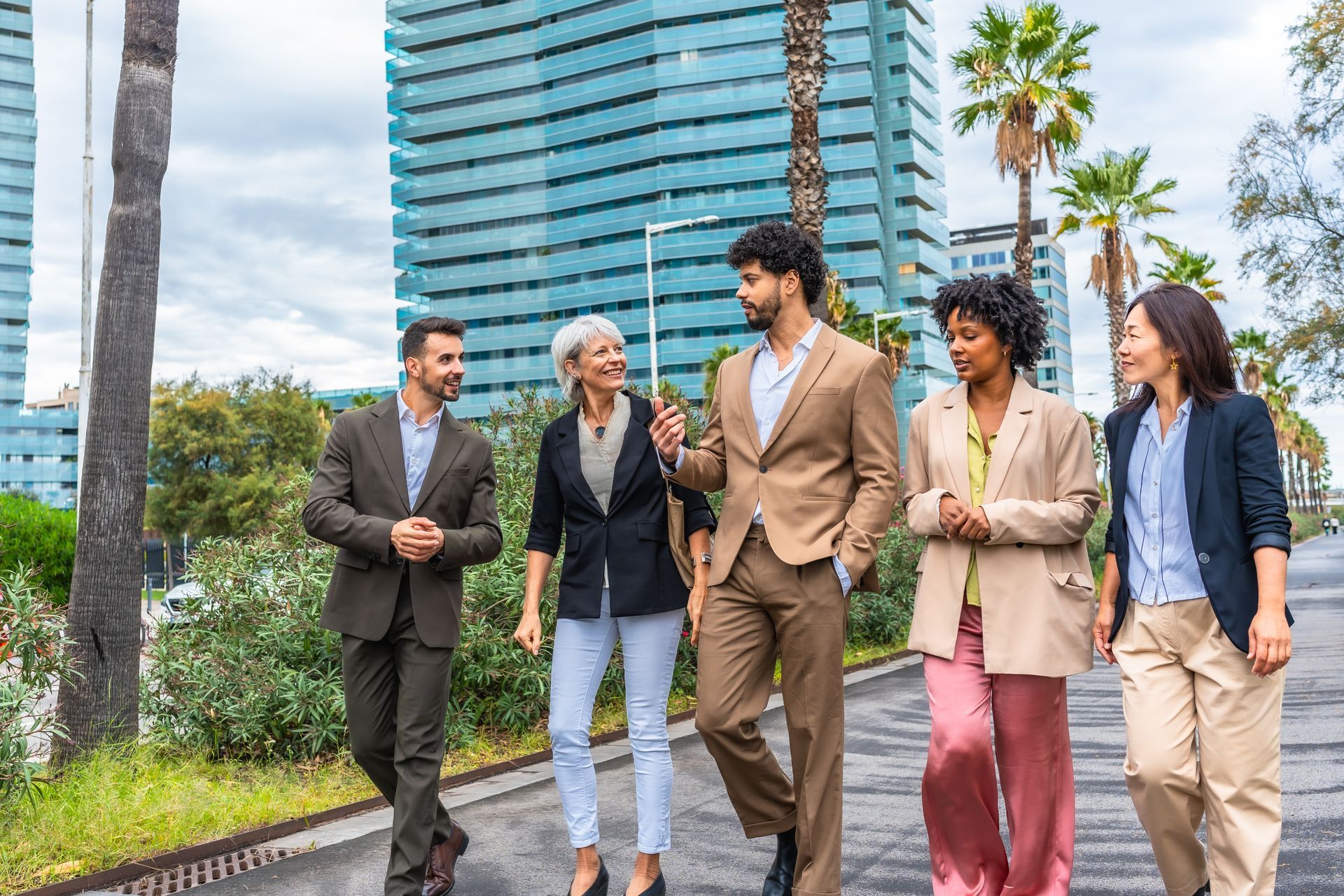 A man and a woman are sitting at a table looking at a laptop.