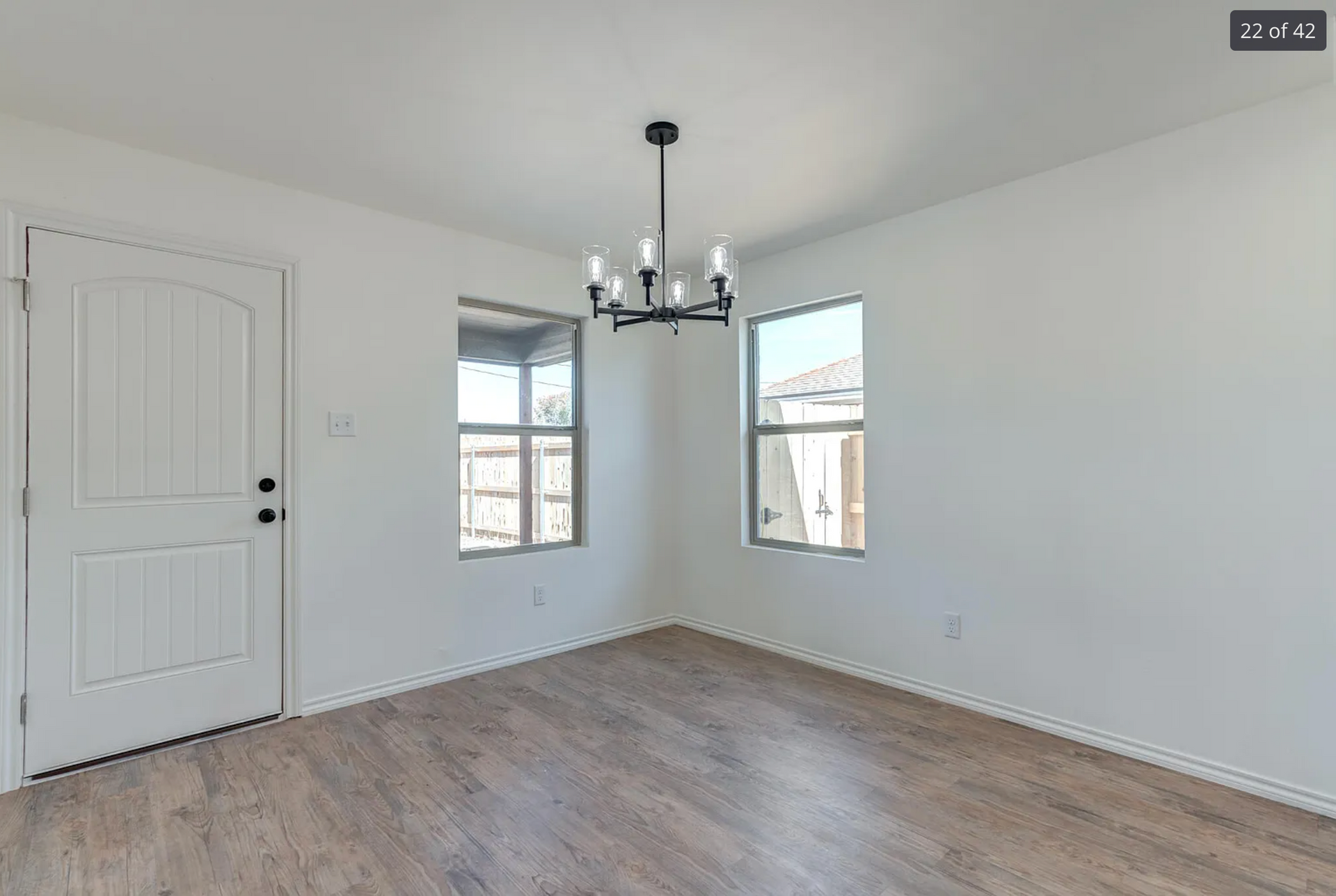 Tree branch fallen on roof, causing damage to a house with gray siding and brick.