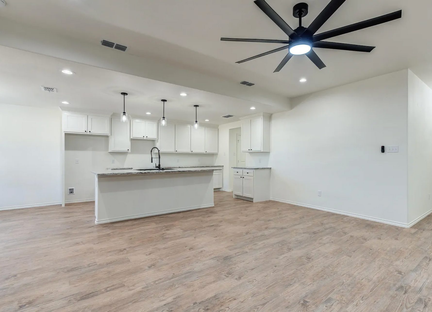 Tree branch fallen on roof, causing damage to a house with gray siding and brick.