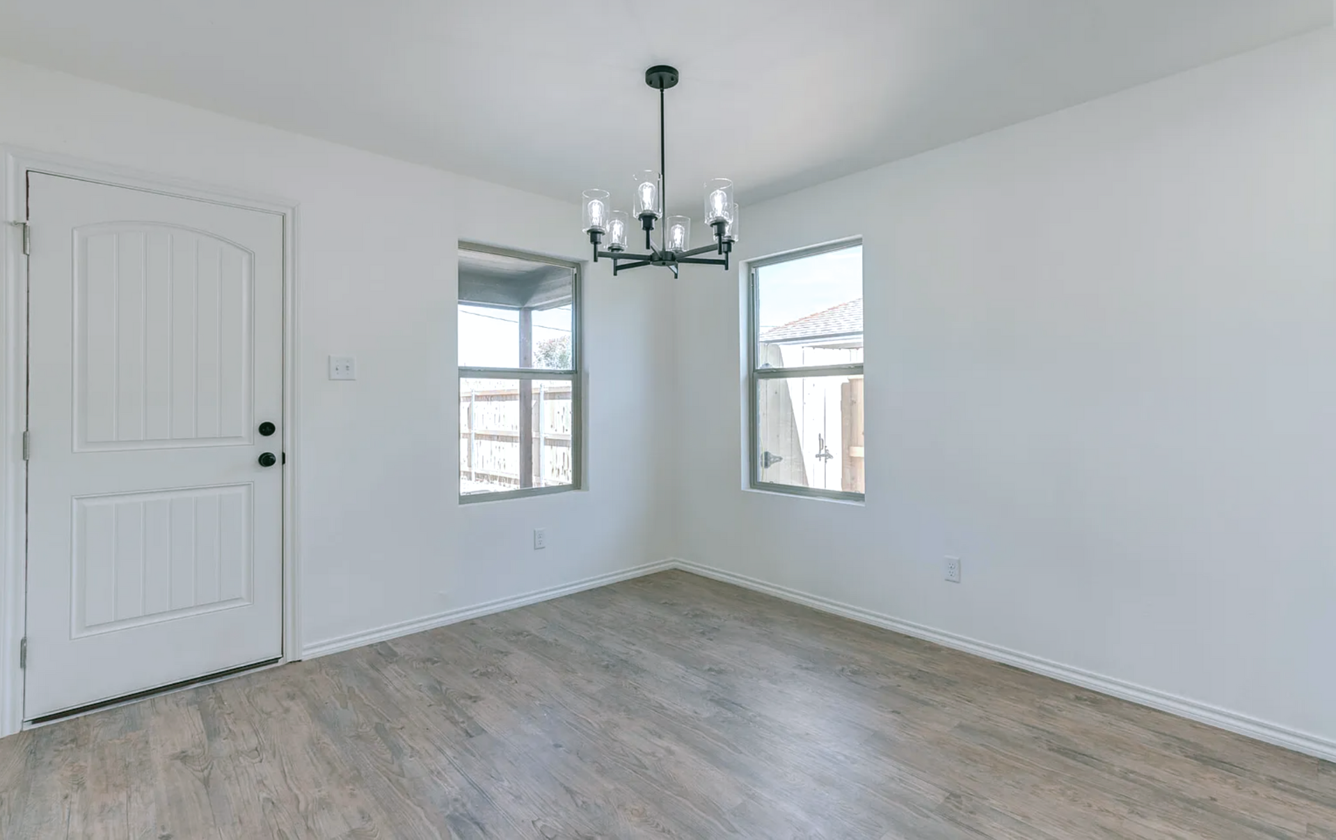 Tree branch fallen on roof, causing damage to a house with gray siding and brick.