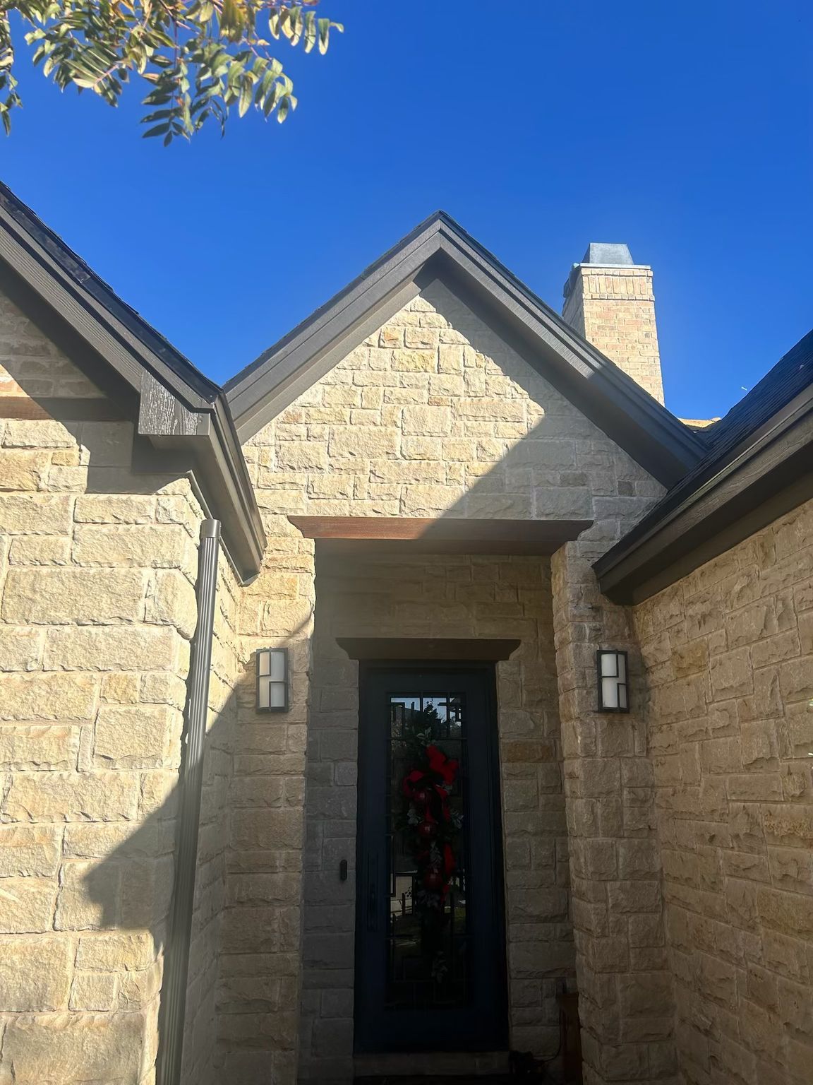 Overhead view of a roof with various grey shingles and metal sections. Skylights visible.