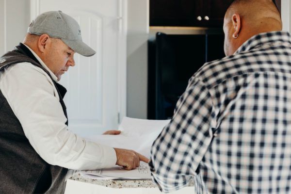 Overhead view of a roof with various grey shingles and metal sections. Skylights visible.