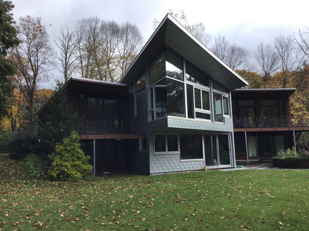 A large house with a lot of windows is surrounded by trees
