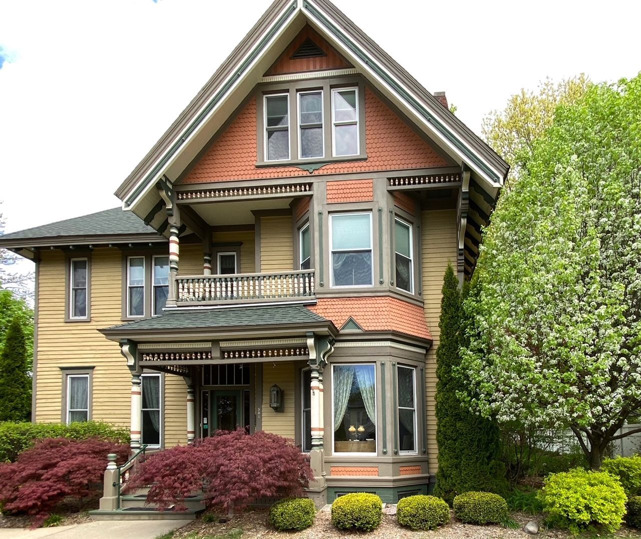 A large yellow house with a red brick facade