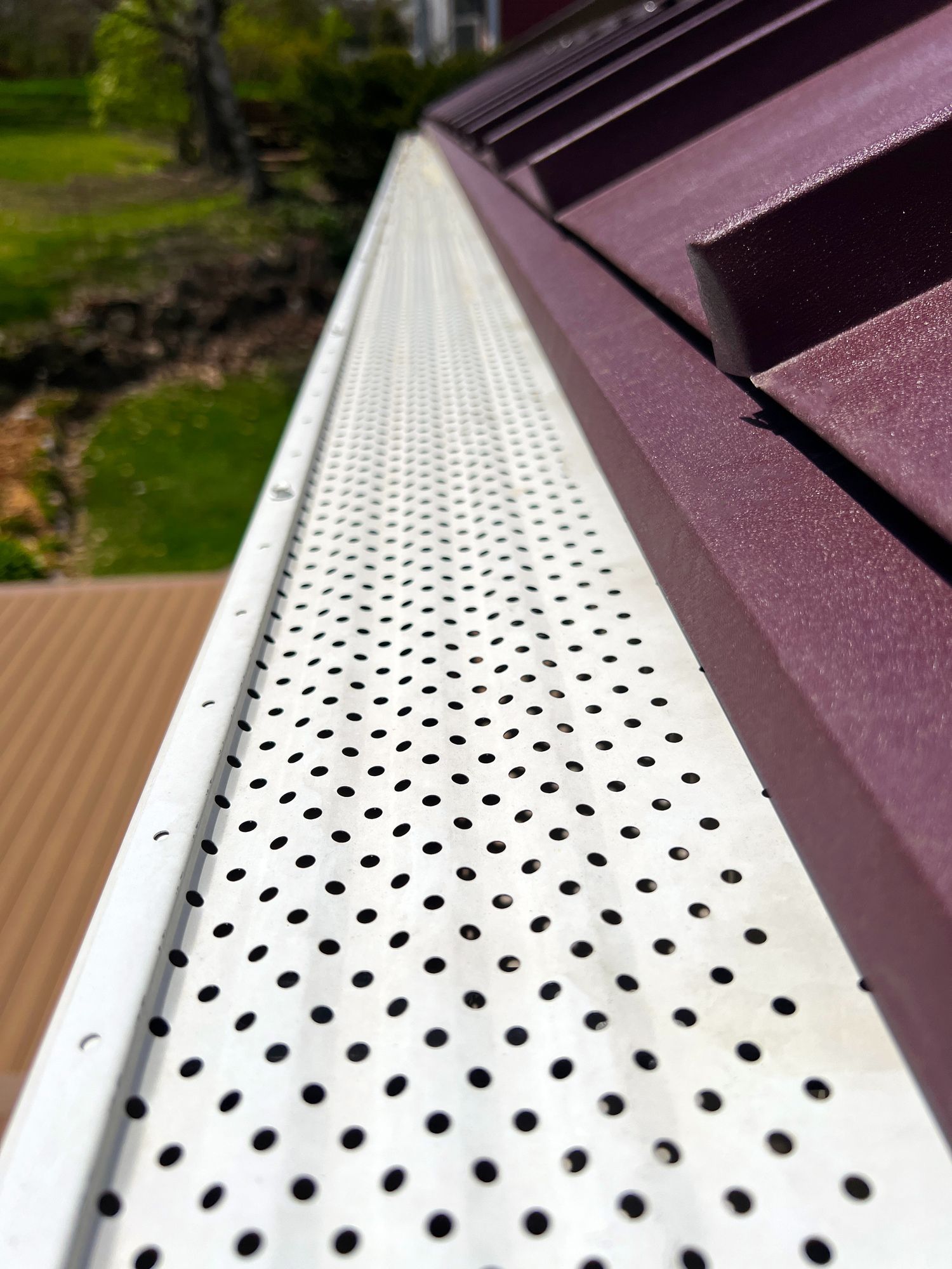 A close up of a white gutter on a purple roof.