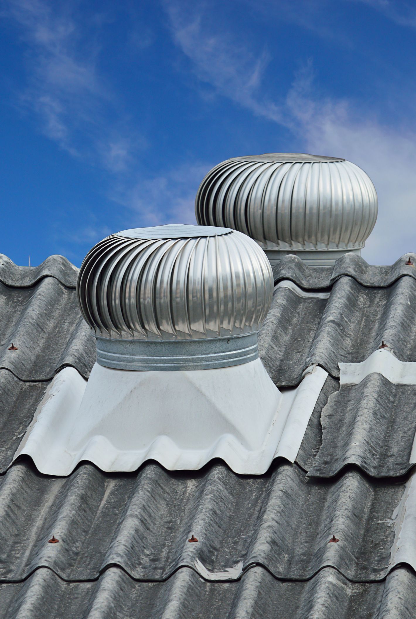 There are two turbines on the roof of a building.