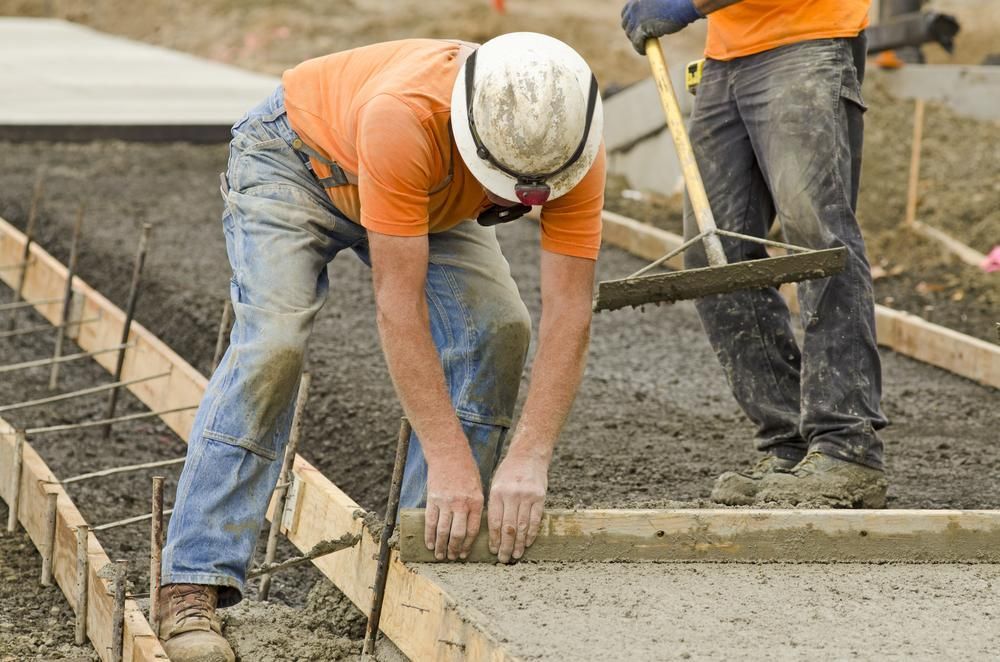 Two Construction Workers Are Working On A Concrete Sidewalk — Tiger Concrete ACT In Fadden, ACT