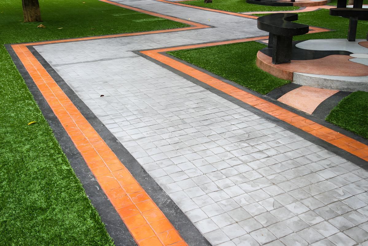 A Brick Walkway In A Park Surrounded By Grass And Benches — Tiger Concrete ACT In Fadden, ACT