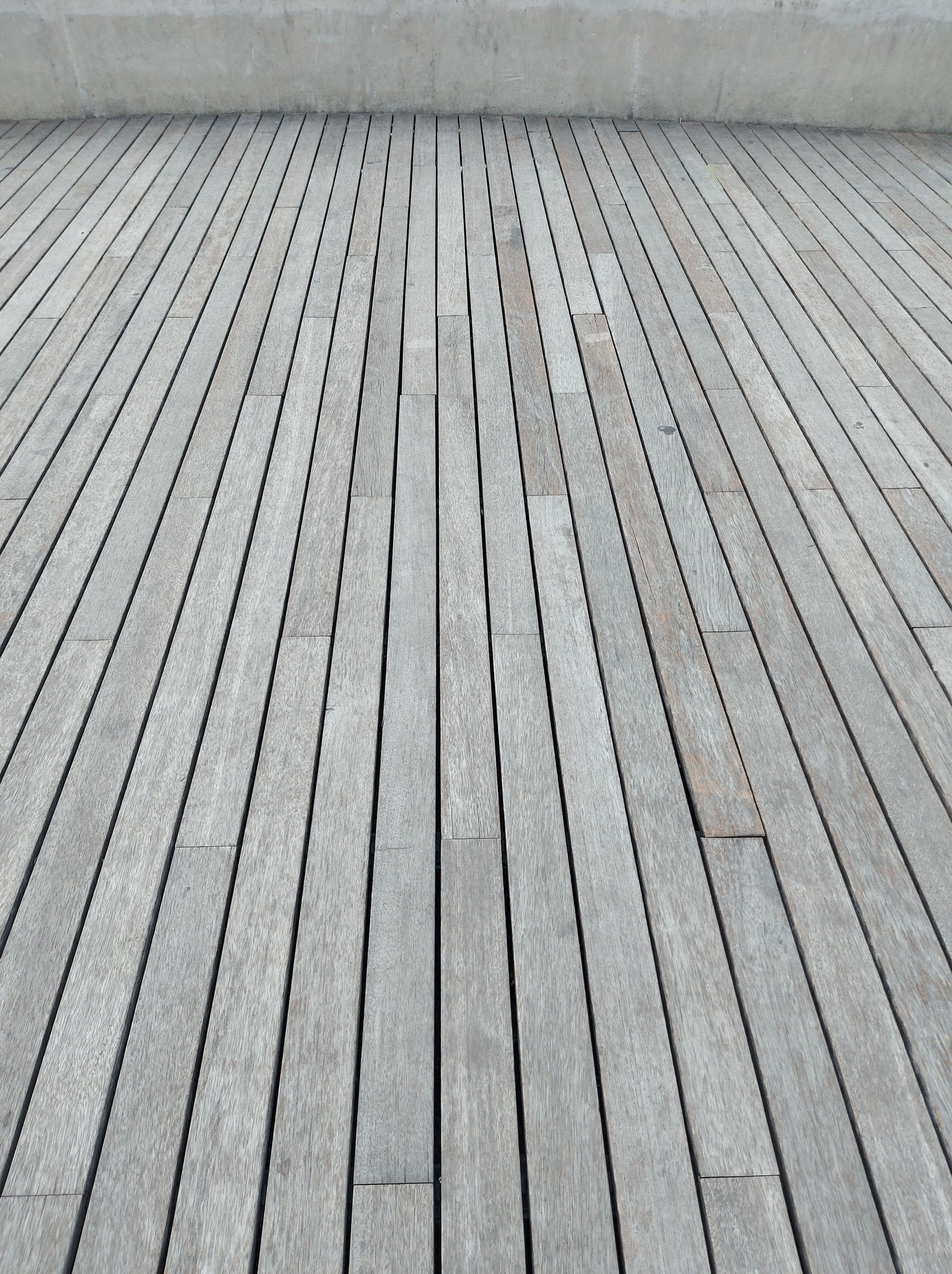 Gray wooden deck planks receding into the distance.