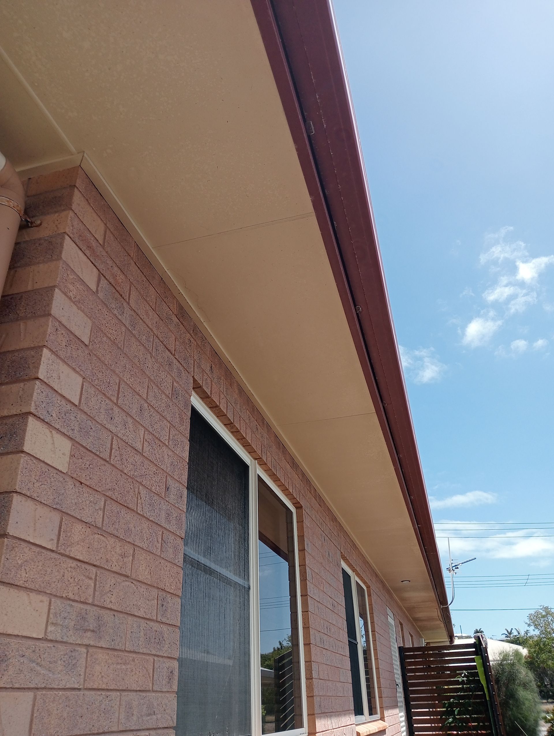 Brick Building Exterior With Brown Roof and a Blue Sky Background — All Sparkles Cleaning Technology In Bowen, QLD