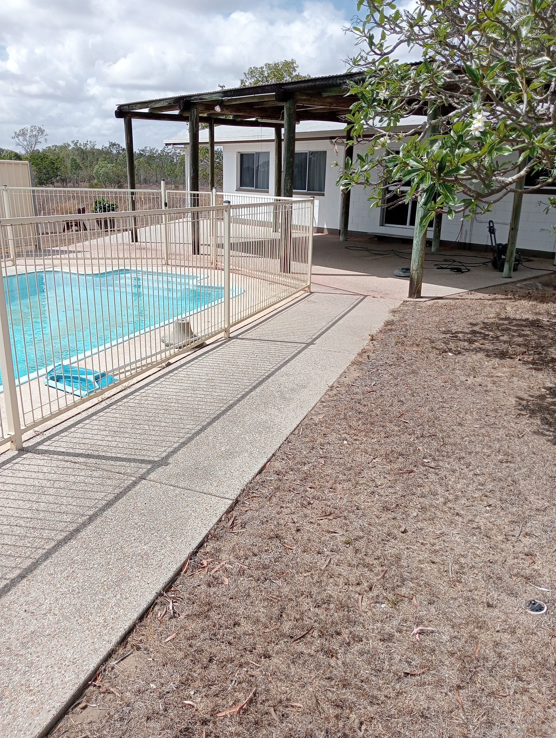 Swimming Pool and Patio Area, Edged by a Pebbled Pathway — All Sparkles Cleaning Technology In Bowen, QLD