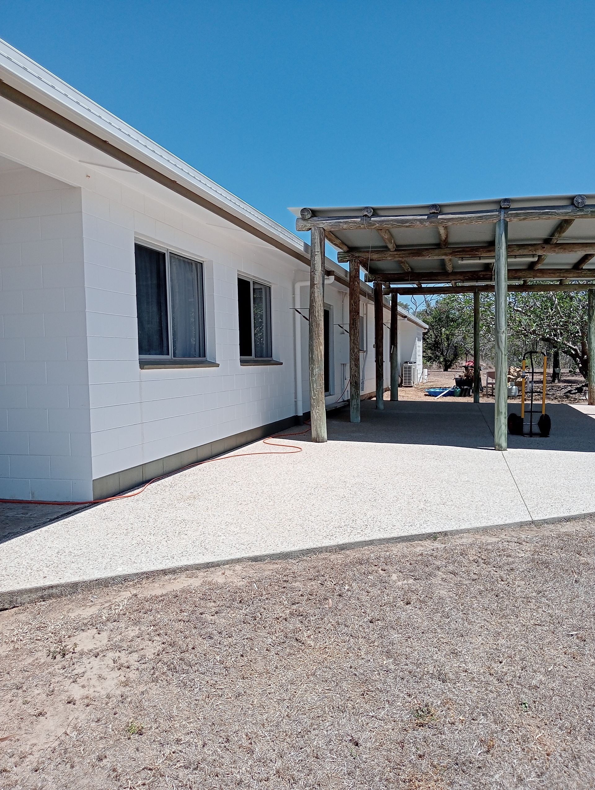 White Building With Carport and Gravel Yard Under a Blue Sky — All Sparkles Cleaning Technology In Bowen, QLD