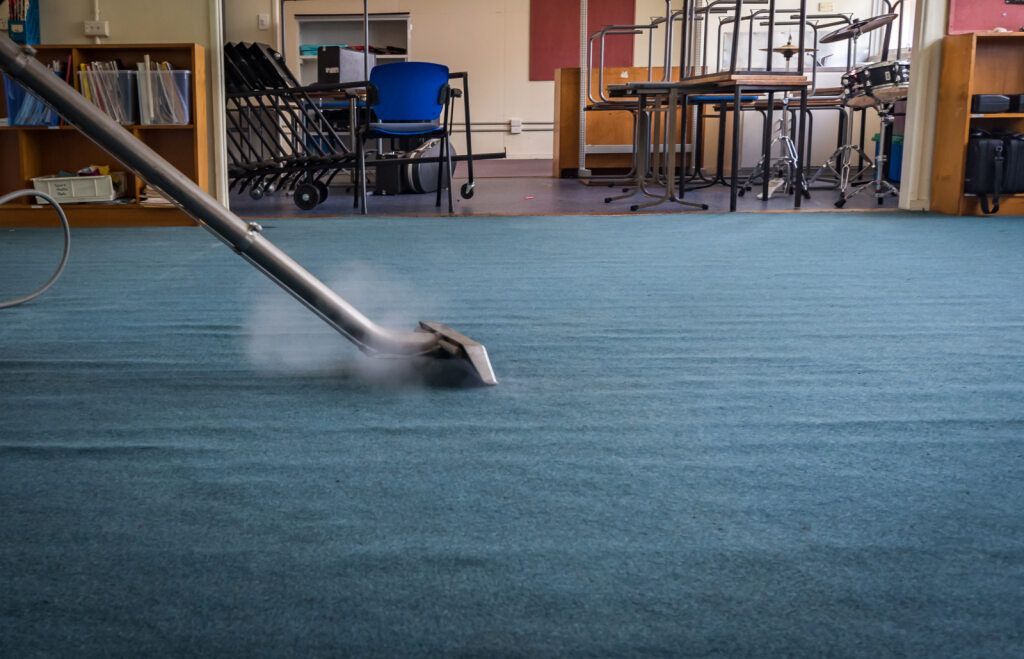Steam Cleaner Cleaning Blue Carpet in a Room With Tables and Chairs — All Sparkles Cleaning Technology In Collinsville, QLD