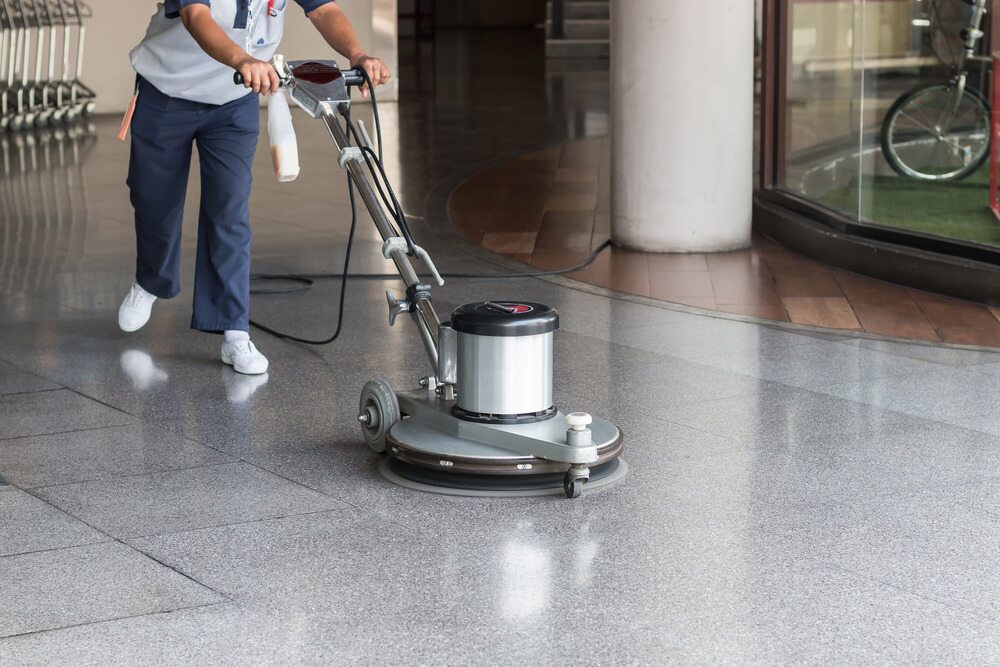 Person Using a Floor Buffer to Clean a Glossy, Tiled Floor Indoors — All Sparkles Cleaning Technology In Airlie Beach, QLD