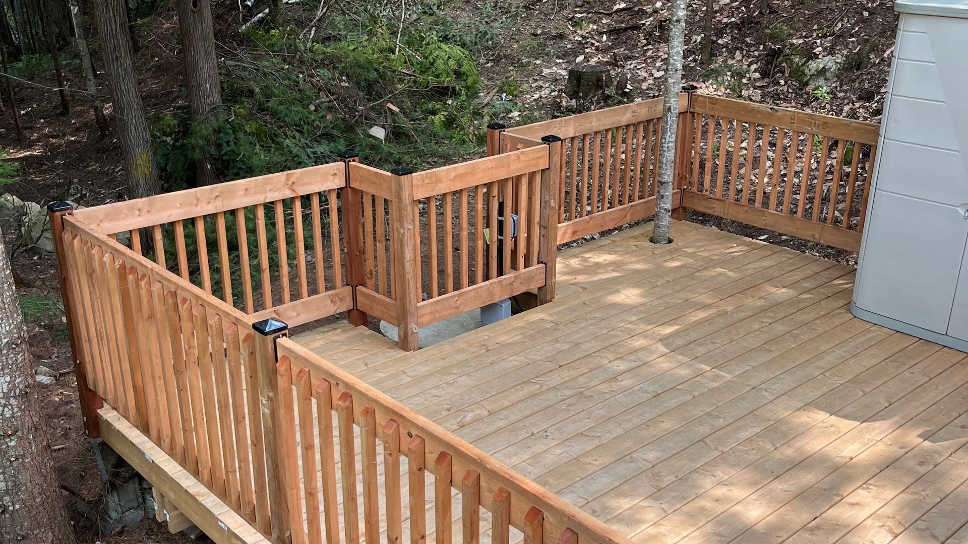 Une terrasse en bois avec une clôture en bois autour.