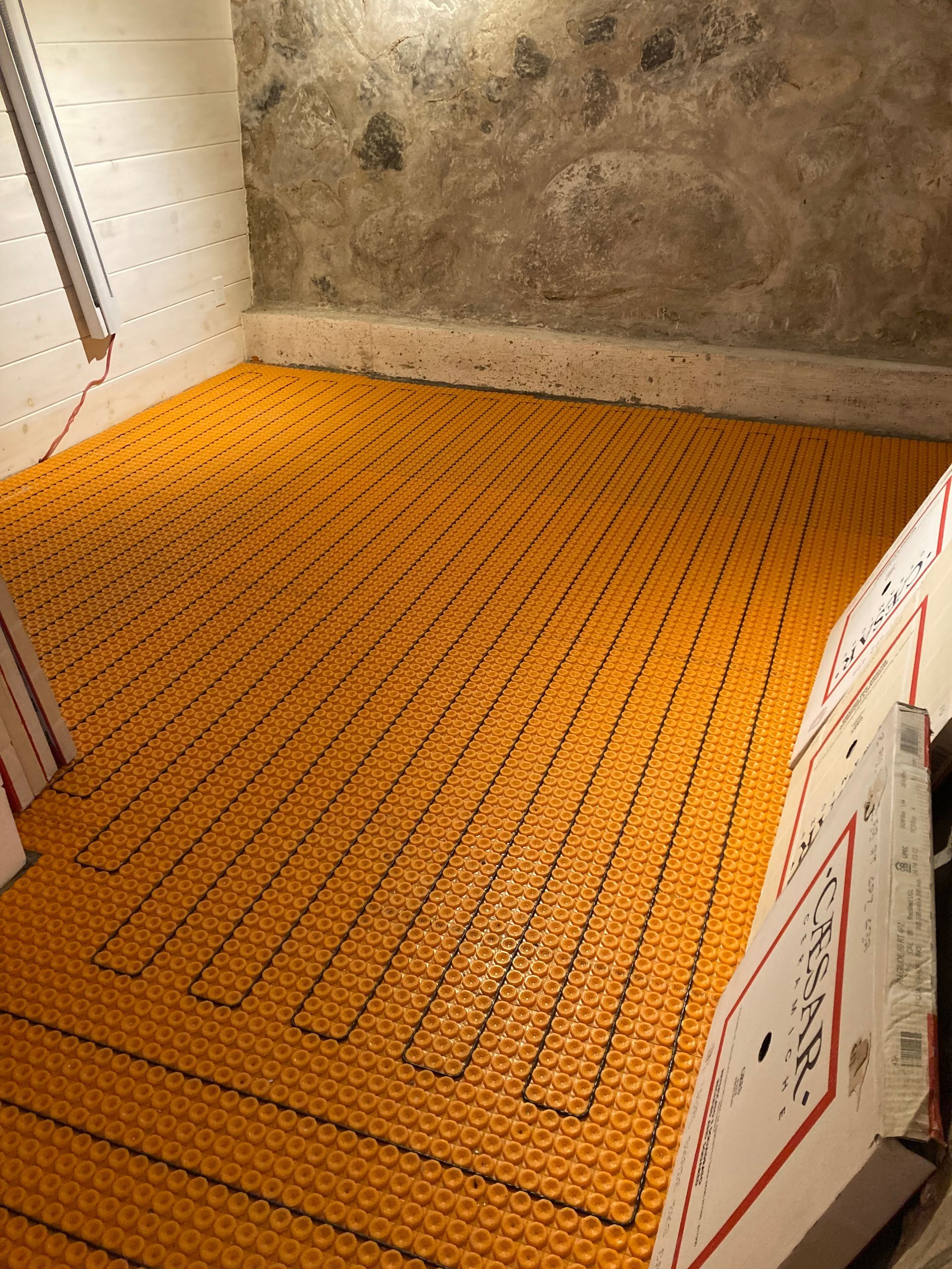 Une pièce avec un mur en béton et un sol jaune