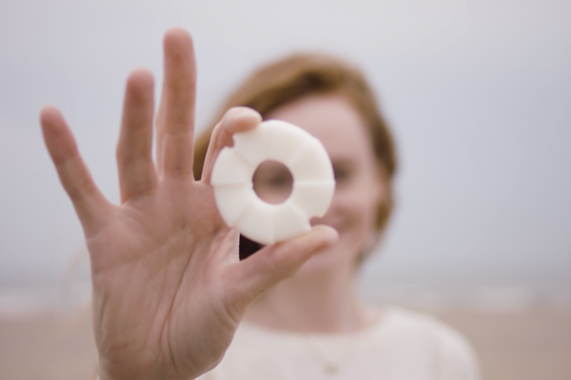 Een vrouw houdt een witte cirkel in haar hand.