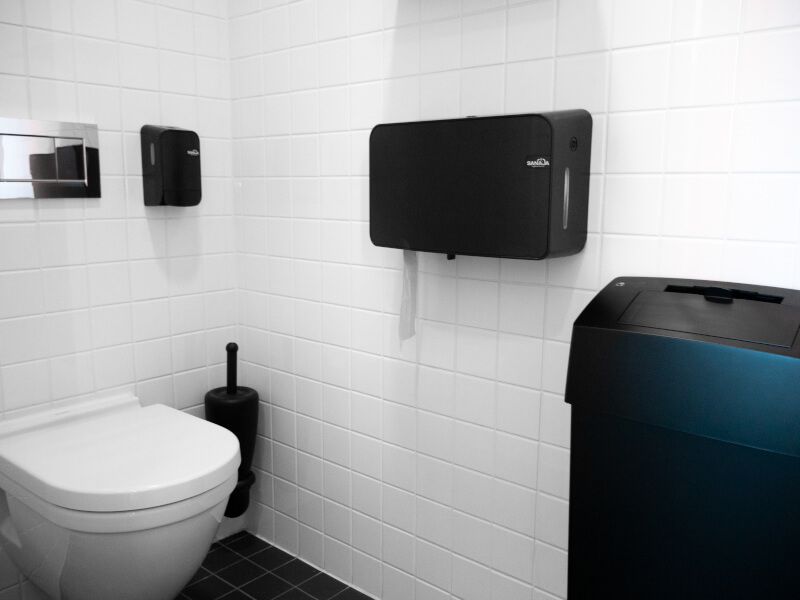 Een badkamer met toilet en prullenbak
