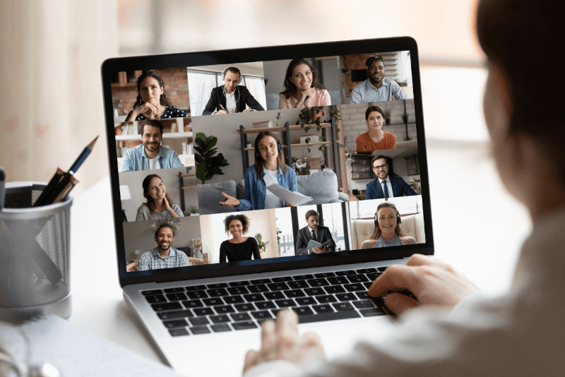 Iemand gebruikt een laptop om een ​​videogesprek te voeren met een groep mensen.