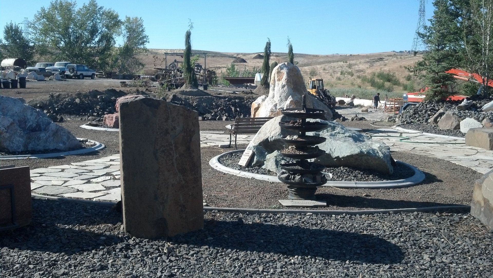 Stone sculpture garden with large rock formations and gravel pathways under a clear sky.