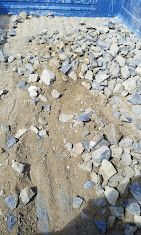 Gravel and sand mix in a blue container, top-down view.