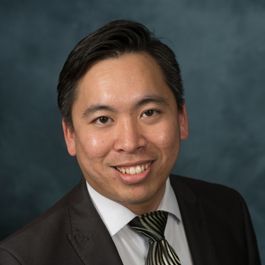 A man in a suit and tie is smiling for the camera.