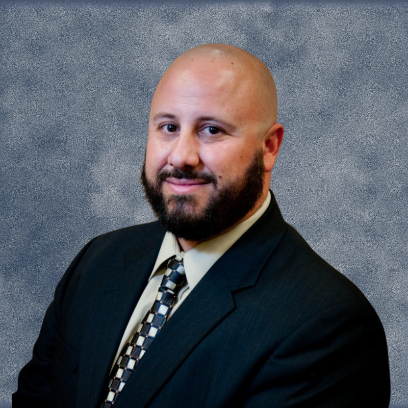 A man with a beard is wearing a suit and tie