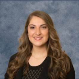A woman with long brown hair is smiling for the camera