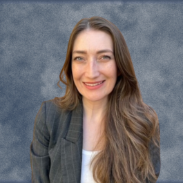 A woman with long brown hair is smiling for the camera