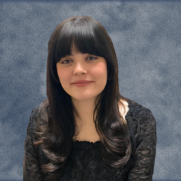 A woman with long hair and bangs is wearing a black lace top